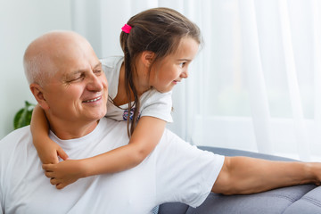 Fototapeta premium Portrait Of Grandfather With Granddaughter Relaxing Together On Sofa