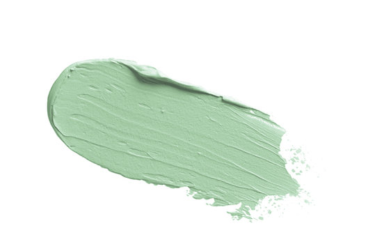 Color corrector stroke isolated on white. Green color correcting concealer cream smudge smear swatch stroke. Make up base creamy texture sample