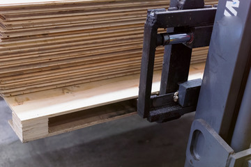 Obraz premium Timber Flooring Factory. Pile of cut wood in factory storage warehouse. Lumber in warehouse.