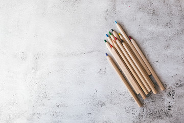 Wooden colored pencils on the gray background