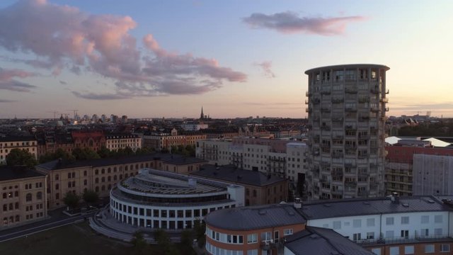 Aerial view of high-rise building in Stockholm, G&auml;rdet at sunset. Drone shot flying by skyscraper tower apartment building, &Ouml;stermalm cityscape skyline in the background. Beautiful sky, Capital city, 
