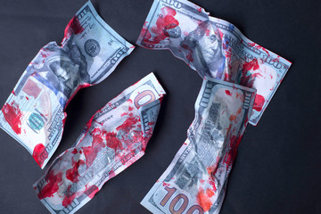 close-up, bloodied crumpled dollar bills lie on a black background. Concept