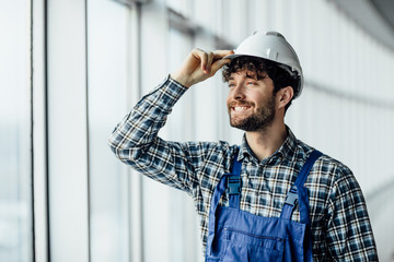 Happy young man architect in hard hat.