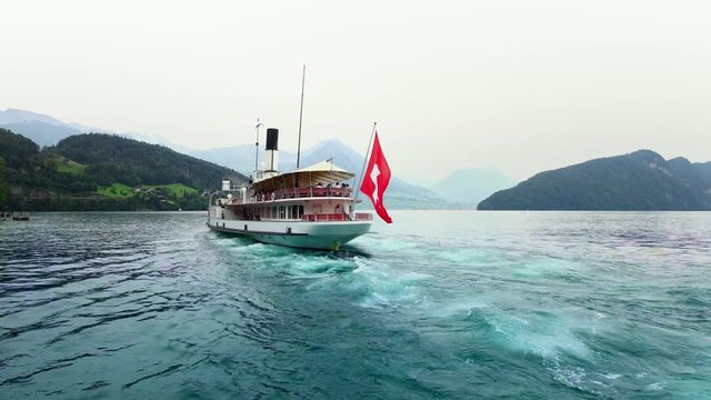 Old steamboat ship on Lake Lucerne, view of Swiss Alps. Swiss Flag. Luzern beautiful Alpine nature. Switzerland summer tourism destination, 4k. 