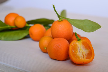 Calamondins on white cutting board