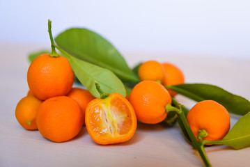 Calamondins on white cutting board