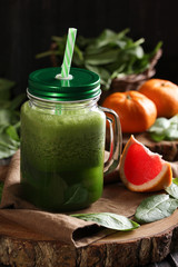 The concept of healthy kitchen. Smoothies with herbs, spinach on a dark wooden background. Background image, copy space