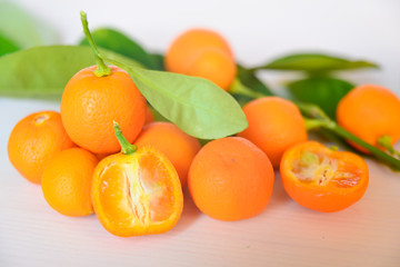 Calamondins on white cutting board