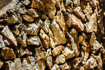 Texture of a stone wall. Natural stone wall texture background. Stone wall as a background or texture. Part of a stone wall with sunlight.