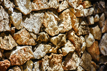 Texture of a stone wall. Natural stone wall texture background. Stone wall as a background or texture. Part of a stone wall with sunlight.