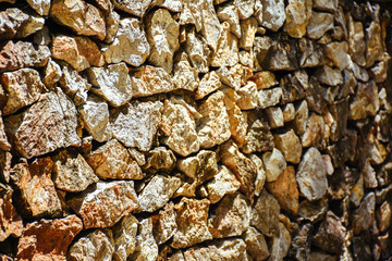 Texture of a stone wall. Natural stone wall texture background. Stone wall as a background or texture. Part of a stone wall with sunlight.