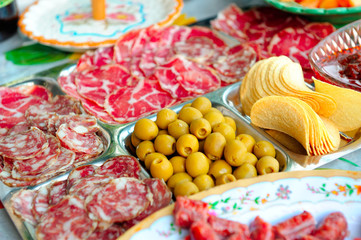 Plate with various Italian - French - Corsican sausages (Pancetta, Coppa...), olives and chips