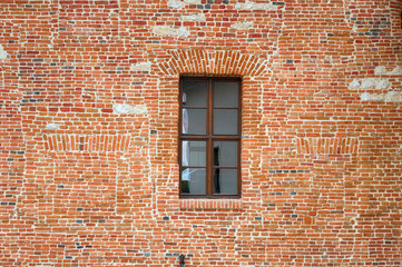 Wooden window in the middle of red brick wall.