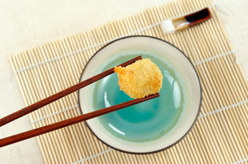 Holding fried Chinese dumpling with chopsticks. ,