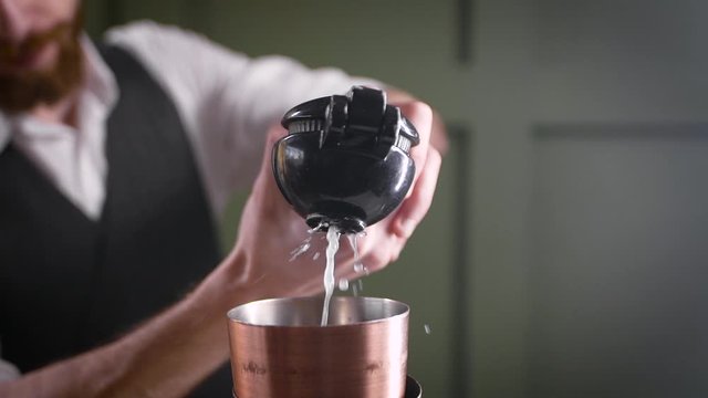 The bartender squeezes lime juice into the shaker. Cooking a citrus cocktail. Bartender's