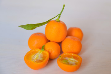 Calamondins on white cutting board