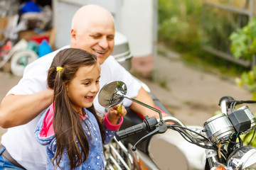 Obraz premium happy grandfather and his granddaughter near bike smiling