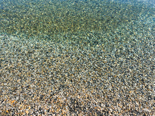 Transparent sea water with pebbles