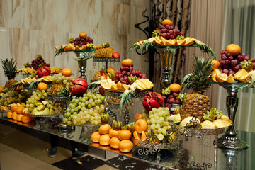 Different fresh fruits on wedding buffet table. Wedding reception catering table with different...