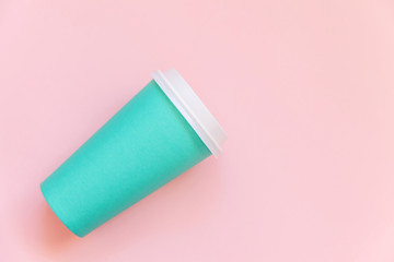 Simply flat lay design blue paper coffee cup on pink pastel colorful trendy background. Takeaway drink container. Good morning wake up awake concept. Template of drink mockup. Top view copy space