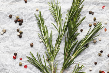 Flat lay composition with fresh rosemary, spices on wooden background, space for text
