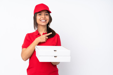 Young Pizza delivery girl over isolated white background pointing to the side to present a product