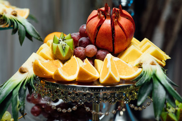 Preparation for design creative menu. Different fresh fruits on wedding buffet table. Wedding day. Abundance of food on the table. Authentic buffet, assorted fresh fruits