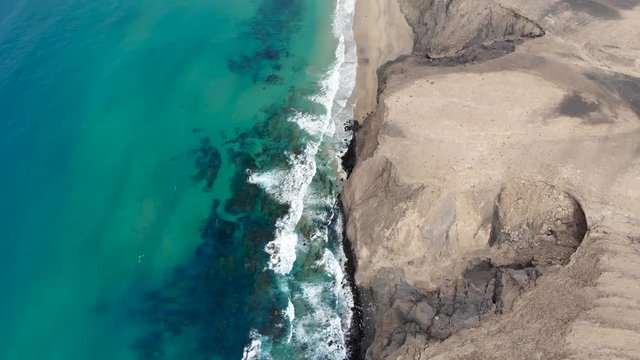Aerial view of blue water hitting the desert in Cofete Fuerteventura. Canary Islands, Spain.