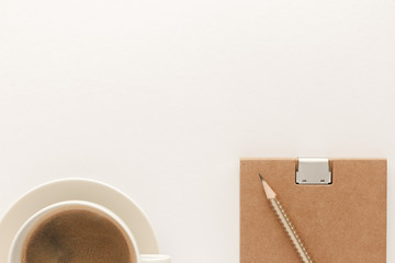 Notepad coffee cup pencil modern business background with copy space for your text. Top view, flat lay.