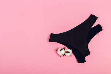 Female pastel cotton set panties and cotton flower on pink background top view flat lay with copy...