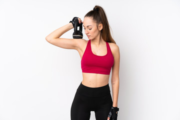 Young sport brunette woman over isolated white background making weightlifting with kettlebell