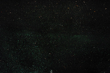 Texture of a dark surface with fine light crumbs. Dark background with sparkles