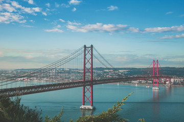 Fototapeta na wymiar Puente rojo 25 de abril de Lisboa en Portugal con cielo y océano azul