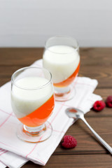 Delicious italian dessert panna cotta with berry jelly on brown wooden background, food concept