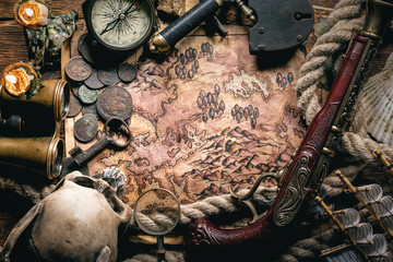 Pirate treasure map on brown wooden table flat lay background.