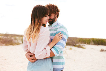 Young couple in love outdoor.Stunning sensual outdoor portrait of young stylish fashion couple posing in summer  on the ocean beach.Close up portrait of smiling young couple having fun outdoors.