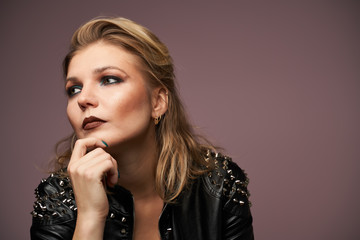 Obraz premium Woman blonde in leather jacket looking at camera isolated in studio