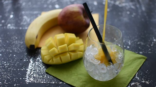 leckeren Mango Smoothie in ein Glas mit Eis schütten