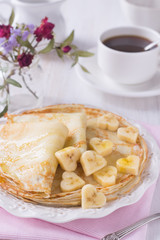 Pancakes with honey and heart shaped bananas for Valentine day