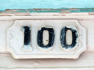 Vintage grunge square metal rusty plate of number of street address with number. Close up, brand.