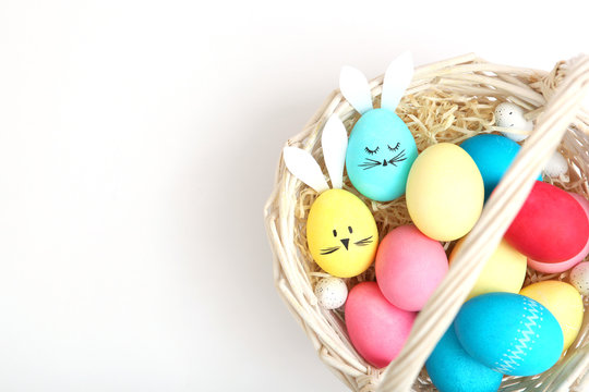 Easter eggs with cute faces and ears on a colored background.
