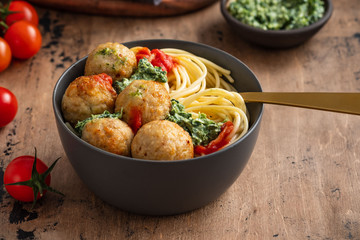 Pasta with meatballs and spinach with tomato sauce.