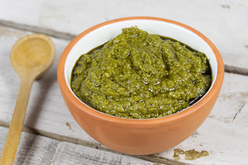 bol de pesto sur un fond en bois