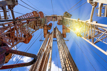 Obraz premium Oil and Gas Drilling Rig onshore dessert with dramatic cloudscape. Oil drilling rig operation on the oil platform in oil and gas industry