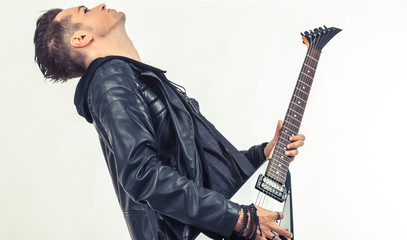 Side view of heavy metal musician playing electric guitar.