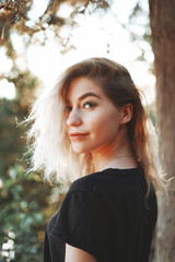 Naklejka premium Cute woman close-up portrait in sunny day outdoor in trees