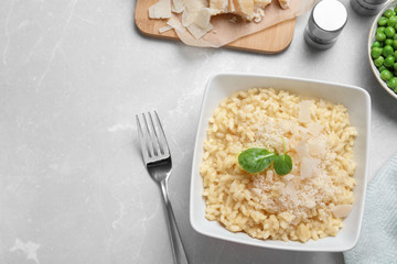 Delicious risotto with cheese on grey marble table, flat lay