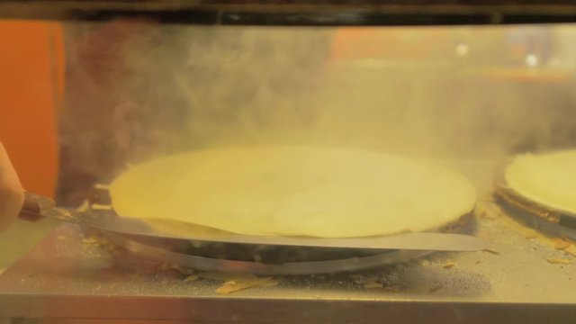 Primer plano de cerca de elaboraci&oacute;n de crepe en plancha con mucho humo
