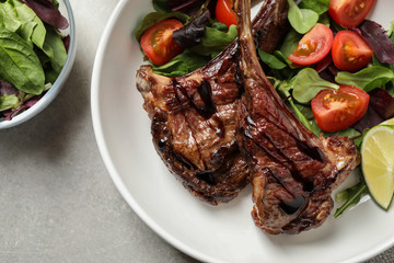 Delicious grilled ribs served on light grey table, flat lay