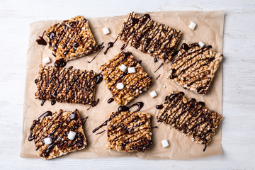 Delicious rice crispy treats on white wooden table, flat lay